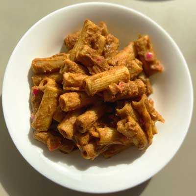 Rigatoni con passata di lenticchie rosse e cipolle marinate